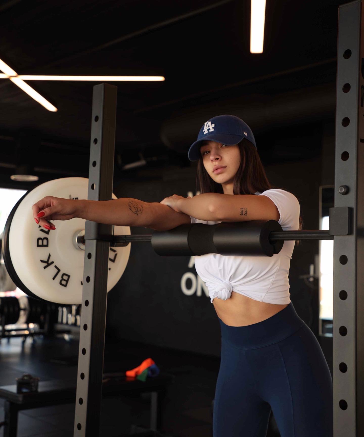 Maya leaning on the squat rack